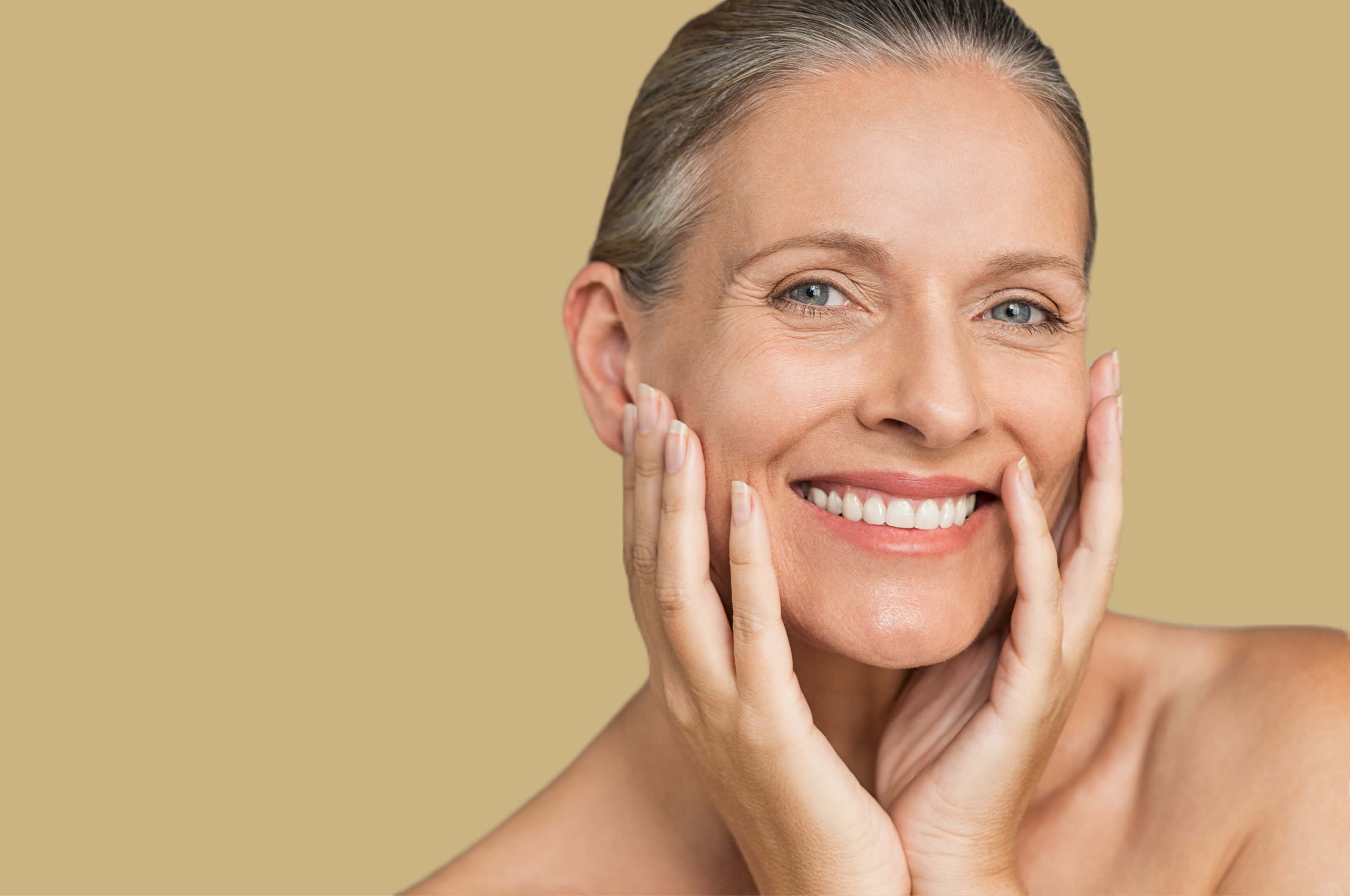 a woman smiling with her hands on her face.